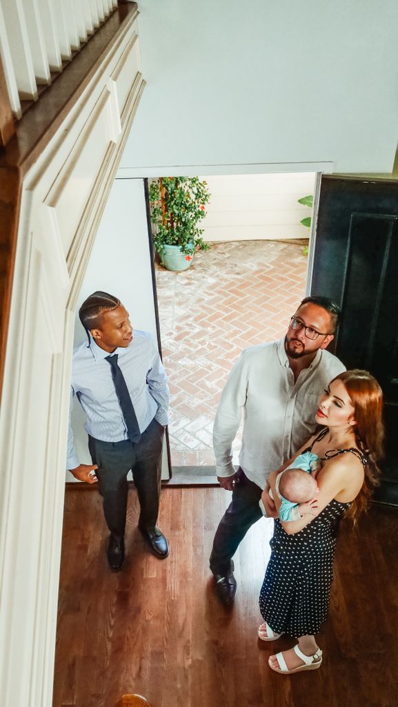 A family with a realtor exploring a new home's interior, considering a property purchase.