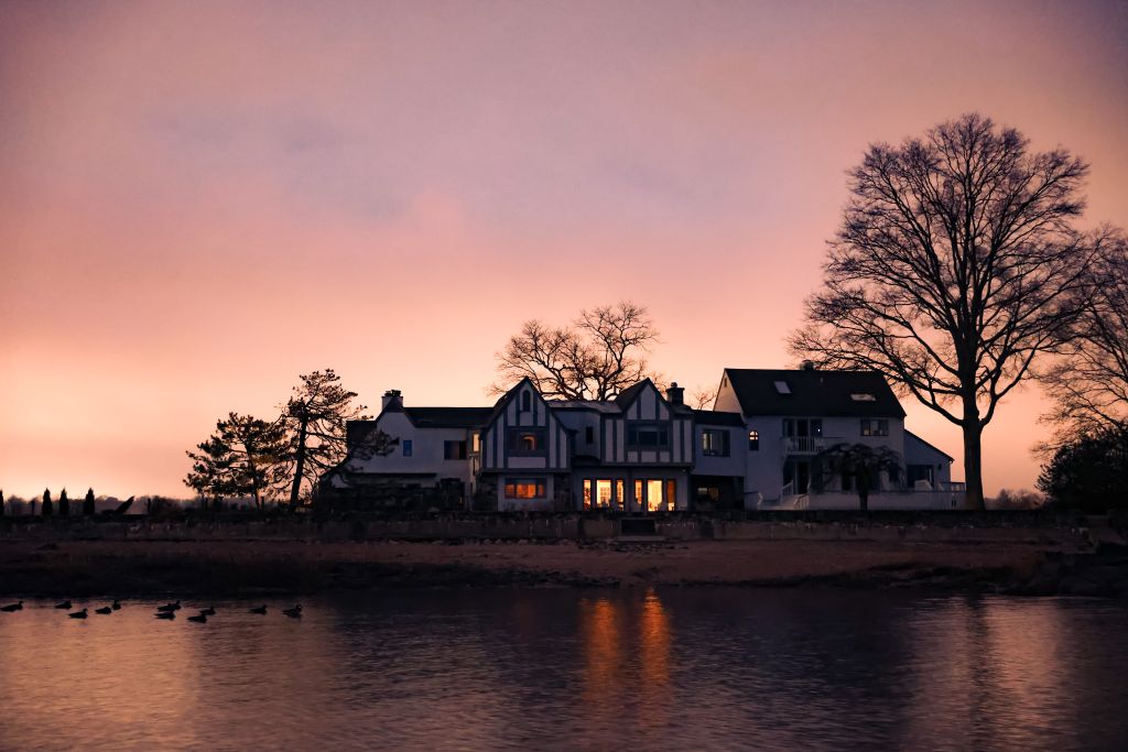 Scenic view of a waterfront house in Stamford, CT during a beautiful sunset.